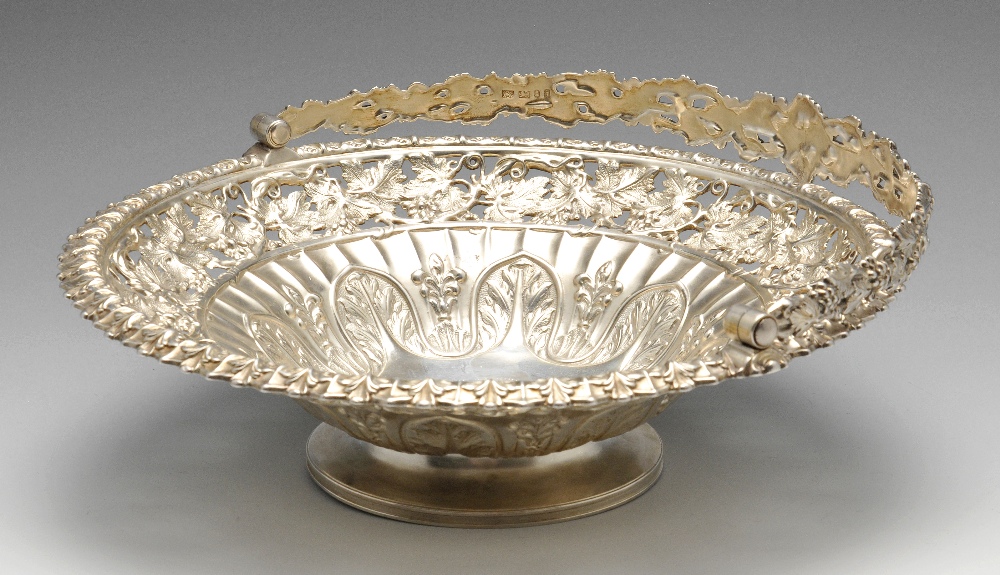 A George IV silver swing handle basket, the circular form fluted and rising to an openwork vine
