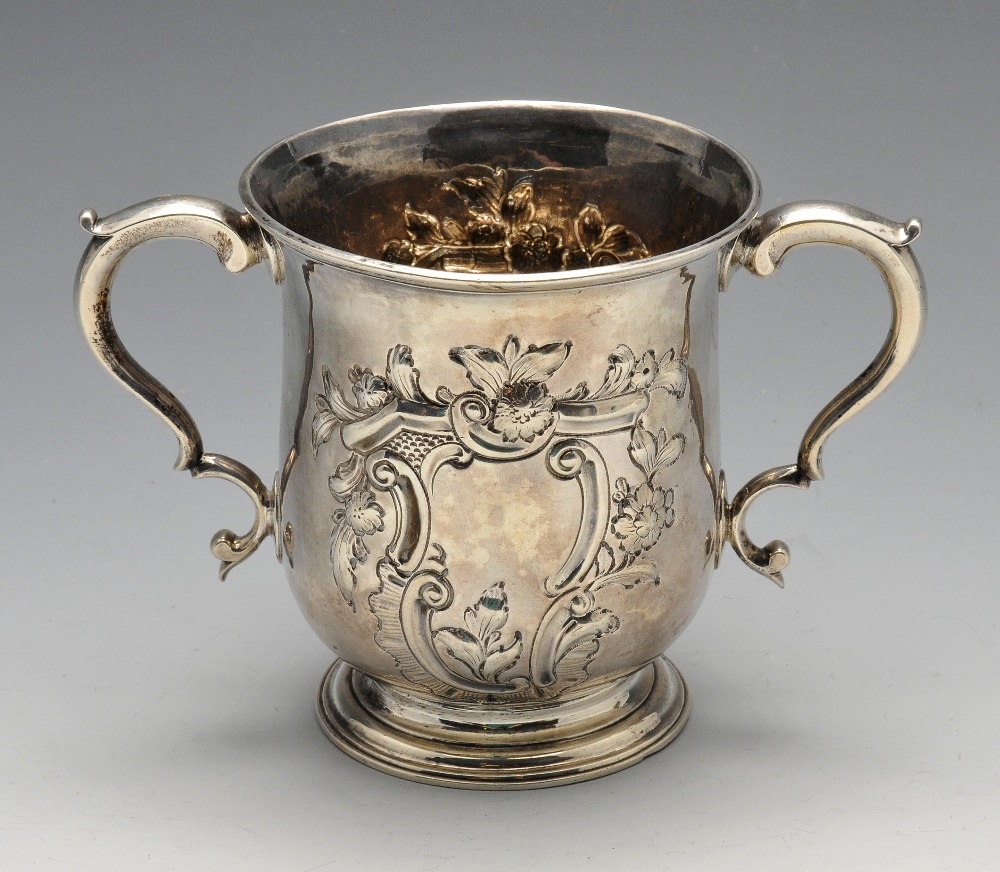 An early George III silver twin-handled cup, the baluster form with dual floral embossed surround to