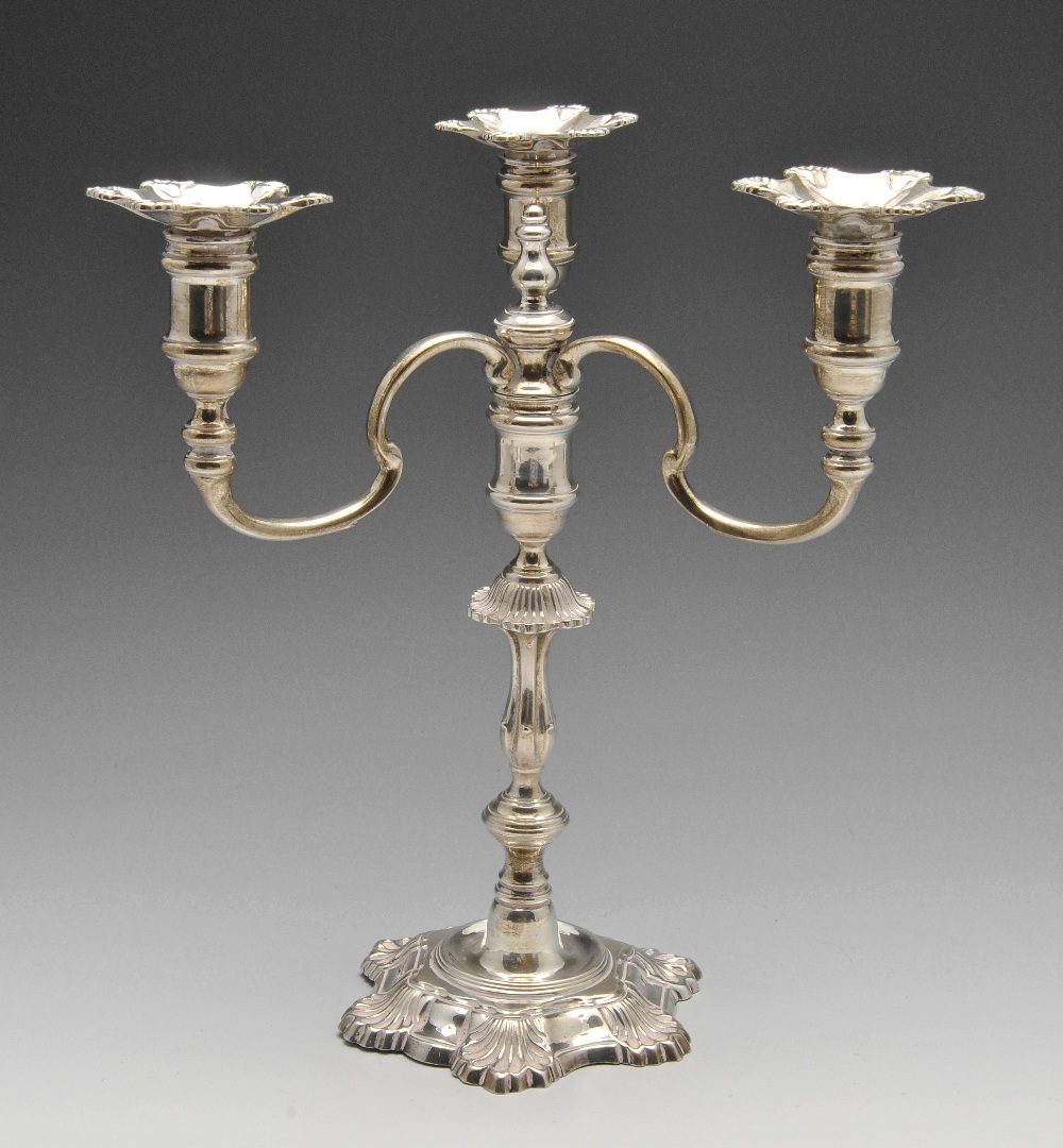 A modern silver candelabrum, the shaped stem standing on a shell embellished base with similar