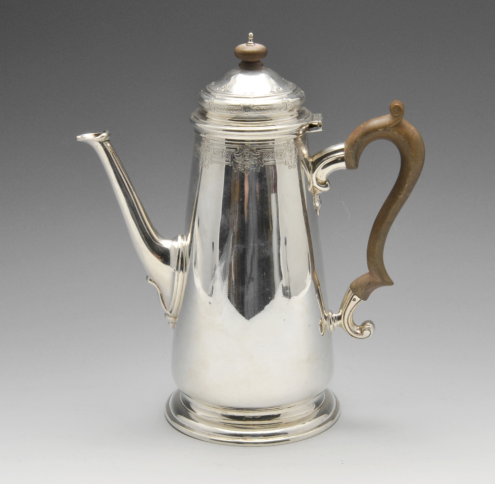 A 1920's silver coffee pot of plain tapered form, the rim and hinged cover embellished with a floral