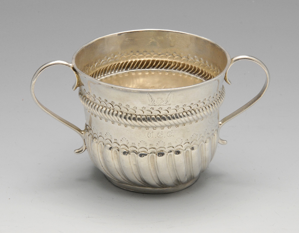 A Queen Anne small silver porringer, of typical form with oblique fluted lower body rising to an