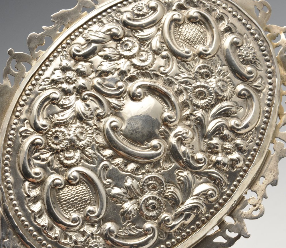 A late Victorian silver mounted hand mirror, the oval bevelled glass plate within an ornately - Image 4 of 8