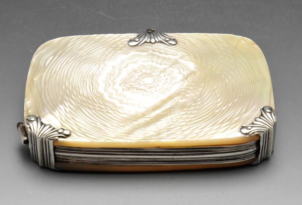 A travelling mother-of-pearl and white metal cased magnifying glass of rounded rectangular form with