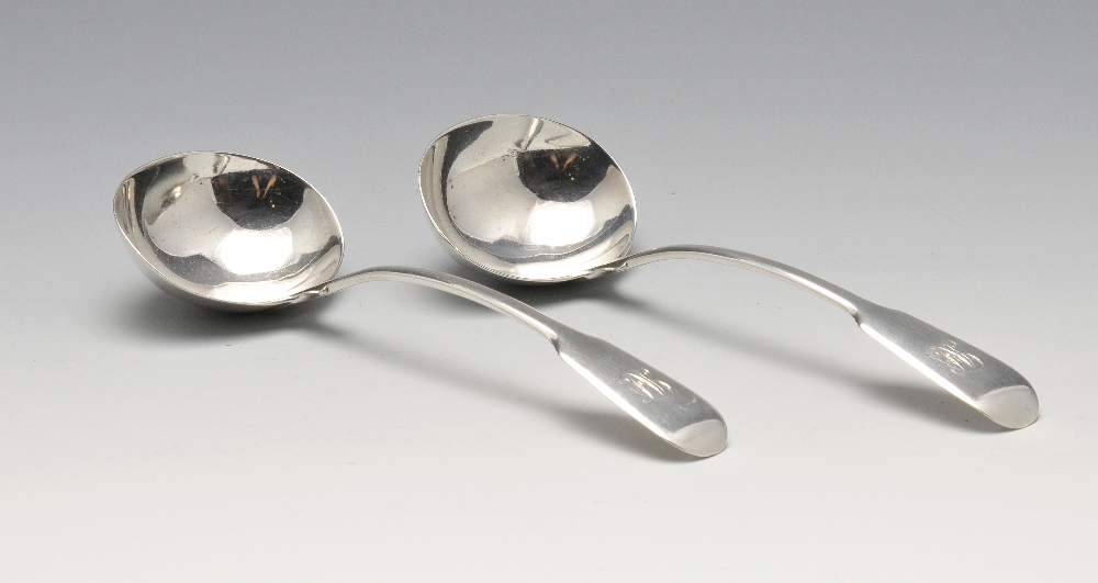 A pair of George III silver sauce ladles, in Fiddle pattern with engraved monograms to terminals.