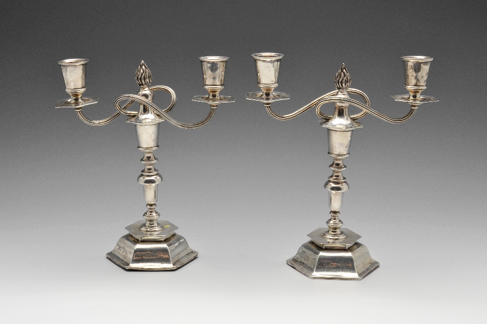 A pair of early twentieth century silver twin branch candelabra, each with hexagonal weighted base