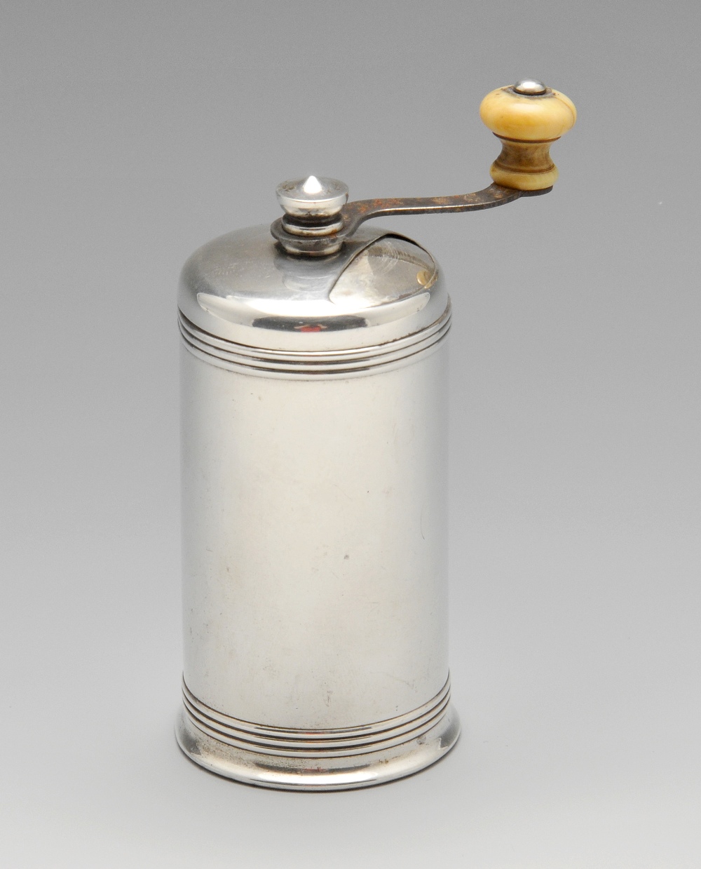 An American sterling silver pepper grinder, the cylindrical form with reeded borders and ivory