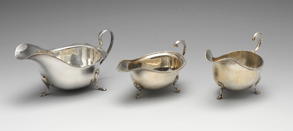 An early twentieth century silver sauce boat of typical form with ribbon and reed rim and raised