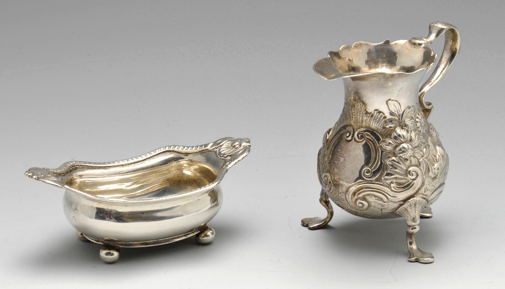 A George II silver cream jug, of globular form having waisted neck and shaped rim, decorated with