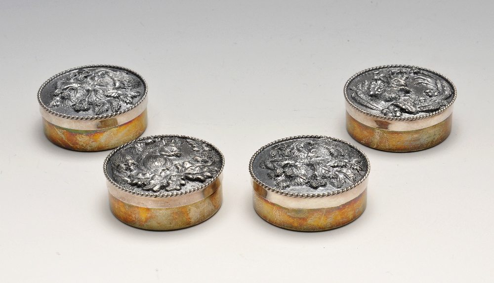 A set of four 1970's silver mounted trinket boxes, each of circular form having base metal plaque