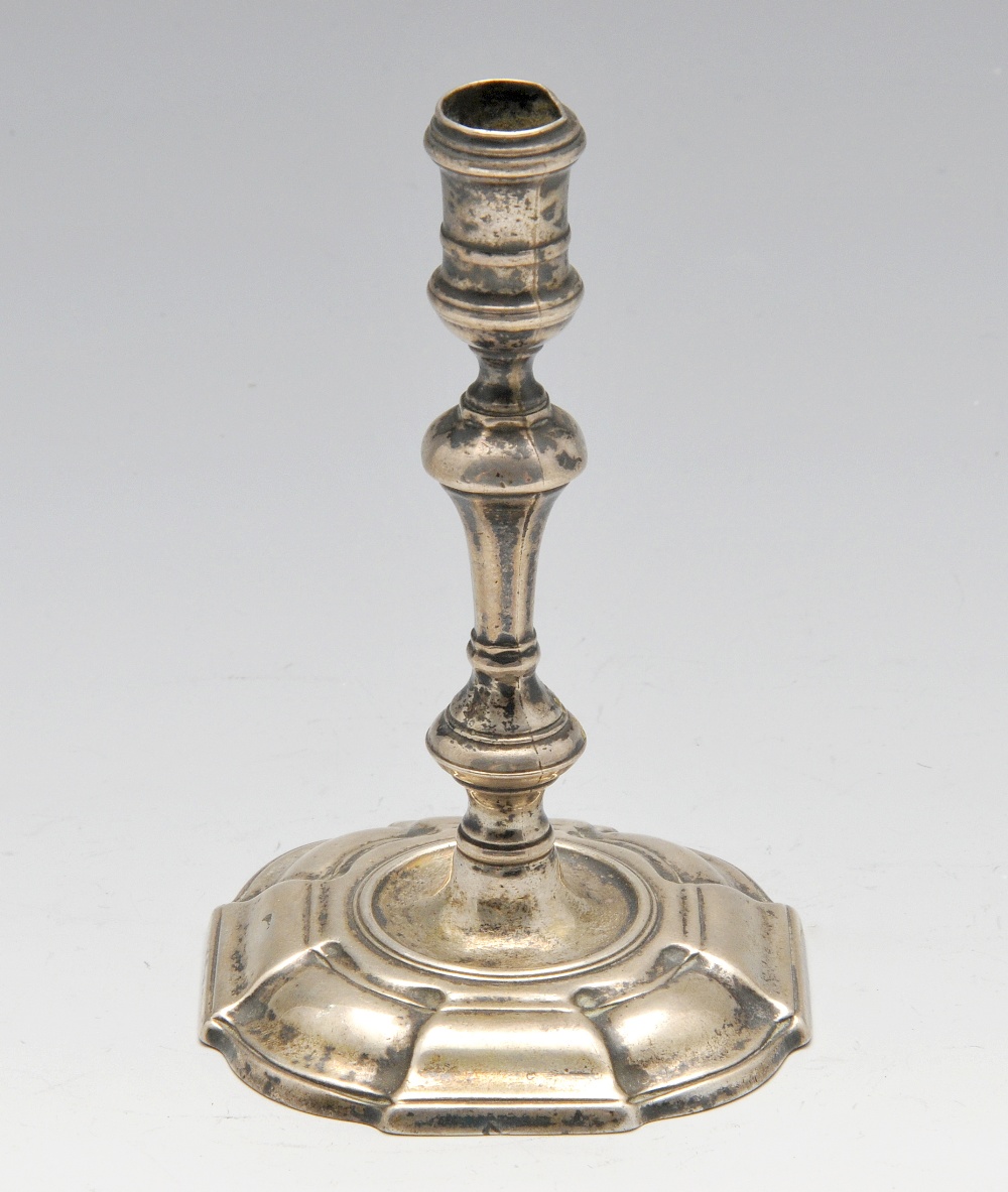 A George II silver taperstick, the knopped baluster stem raised on a crested octagonal fluted