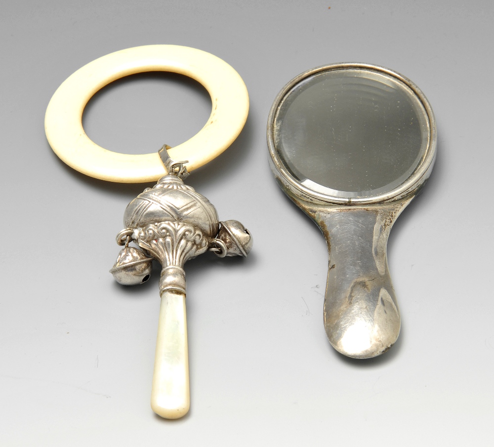 An Edwardian silver mounted small hand mirror, the bevelled mirror plate of oval form and