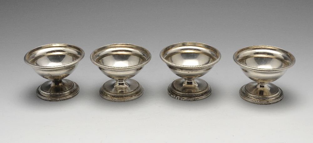 A George III matched set of four silver pedestal open salts of hemispherical form with gadrooned