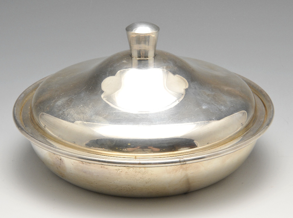 A mid-twentieth century silver entree dish of plain circular form, the cover opening to a detachable