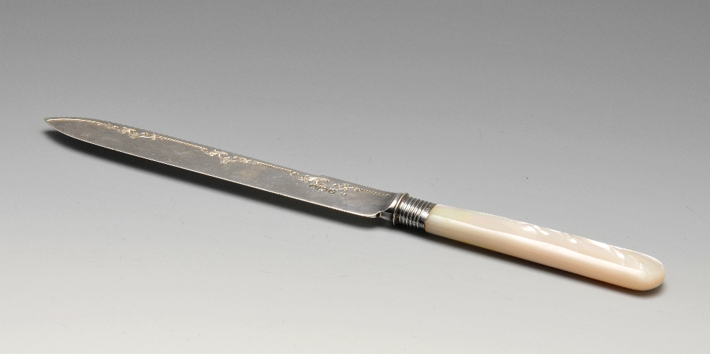 A George V silver bread knife, the blade having scrolling border to the serrated edge leading to the