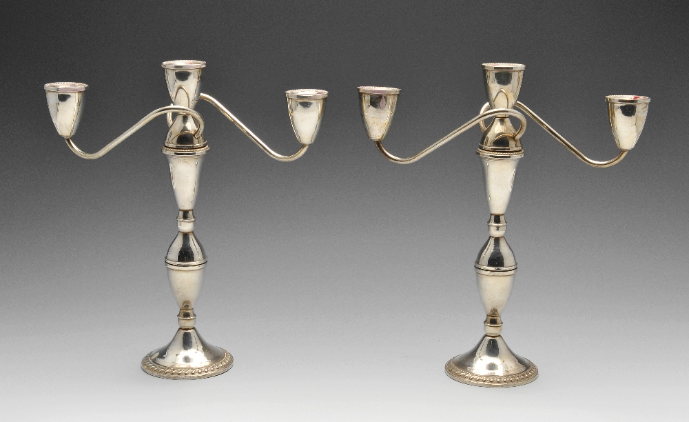 A pair of American mid-twentieth century twin branch candelabra, each with circular filled base