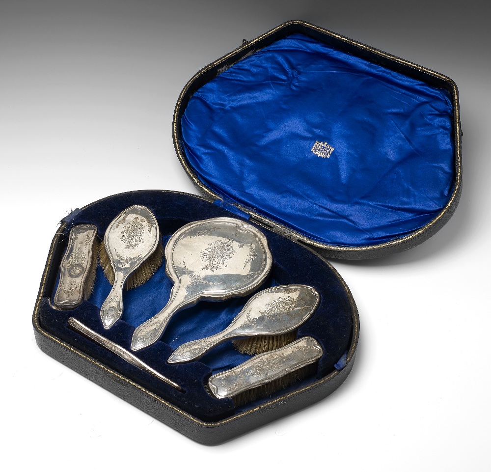 An early twentieth century silver mounted dressing table set, comprising a hand mirror, a pair of