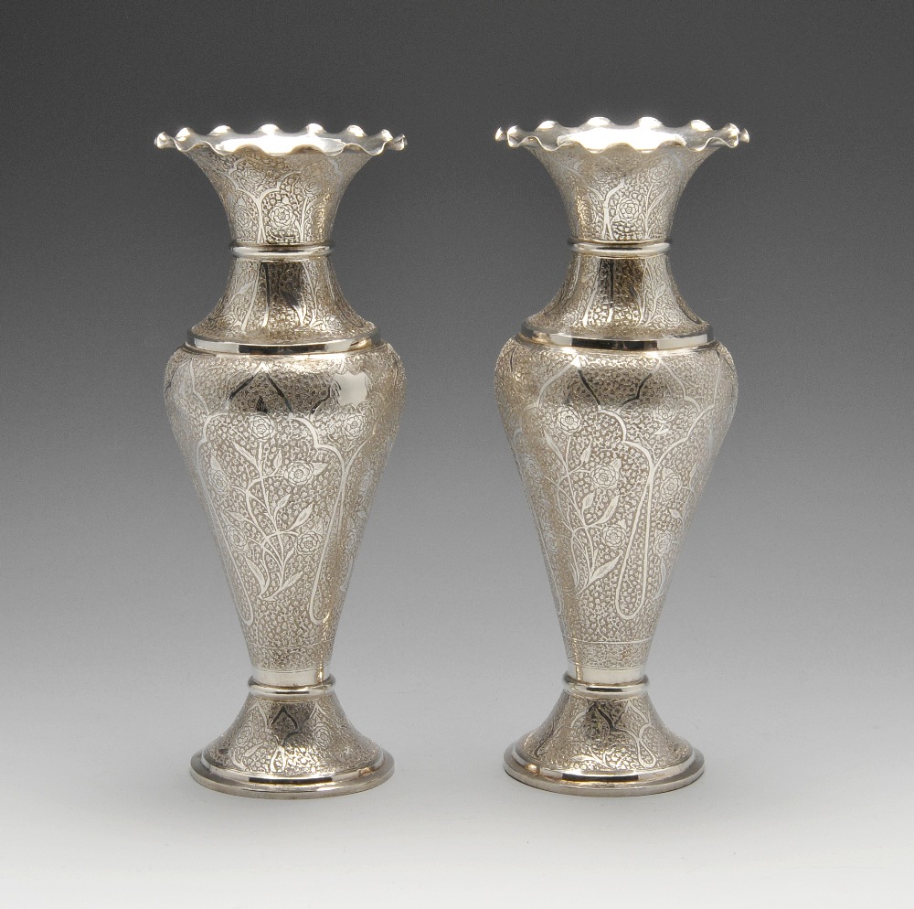 A pair of large white metal Persian vases, the urn form with flared and scalloped rim, the whole