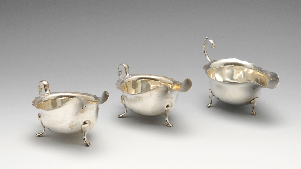 A pair of mid-twentieth century silver sauce boats of classic form with scalloped rim and standing