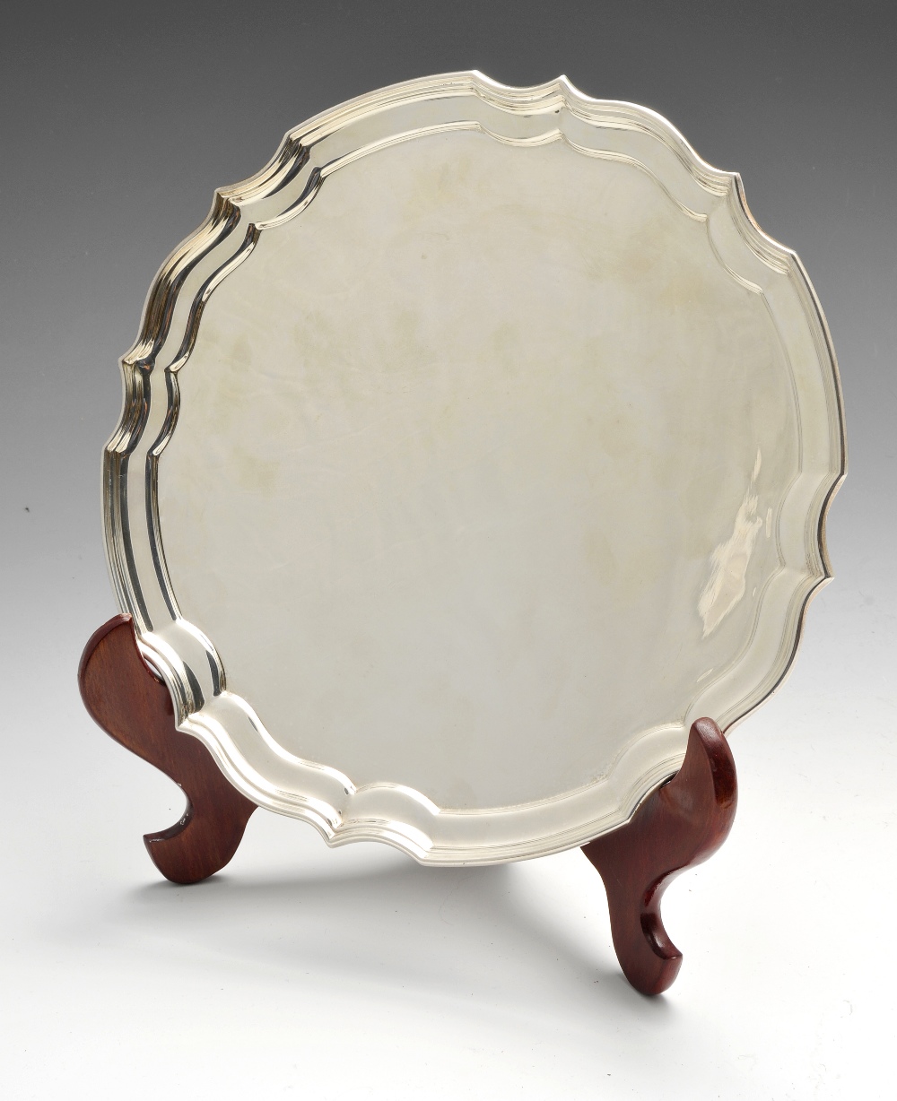 A modern silver salver by Albert Edward Jones, the circular body with Chippendale style border.