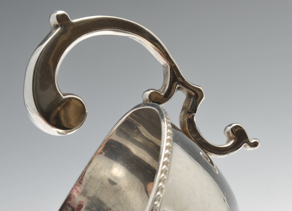 A 1930's silver sauce boat of typical bellied form having a shaped rim and raised on three - Image 3 of 8