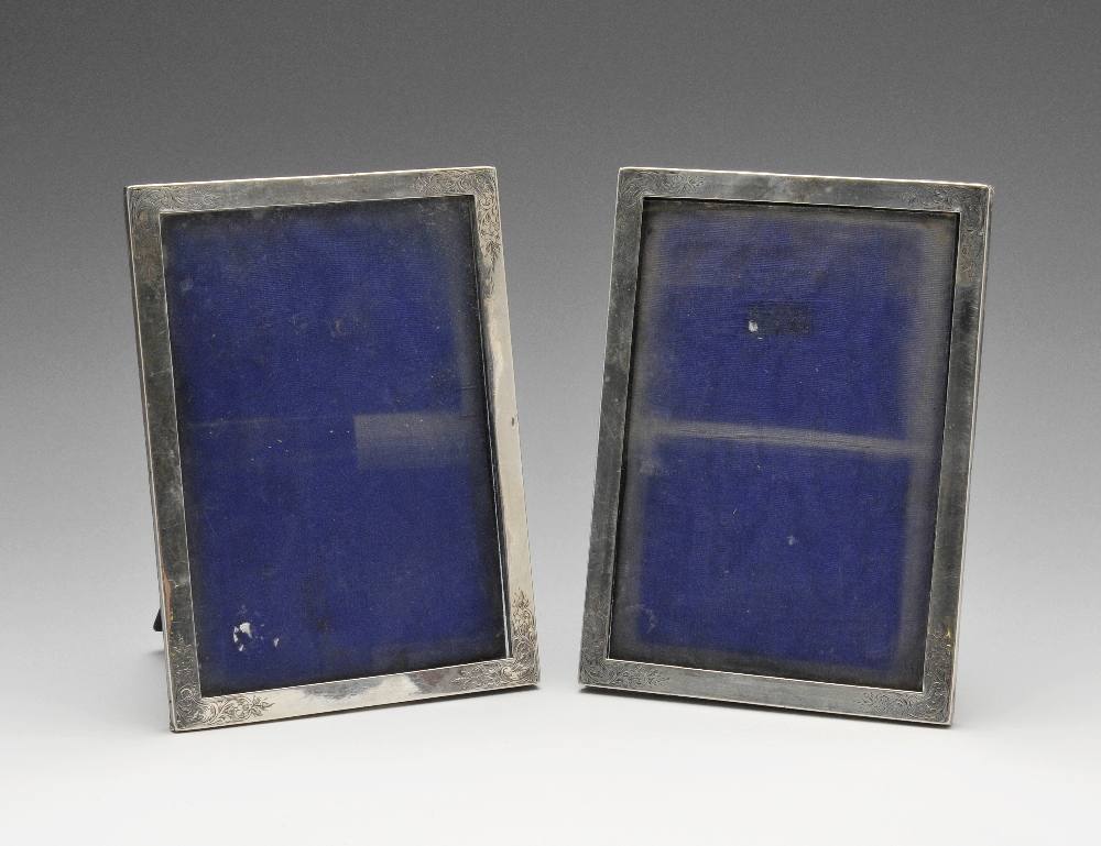 A pair of Edwardian silver mounted photograph frames, each of easel back rectangular form with