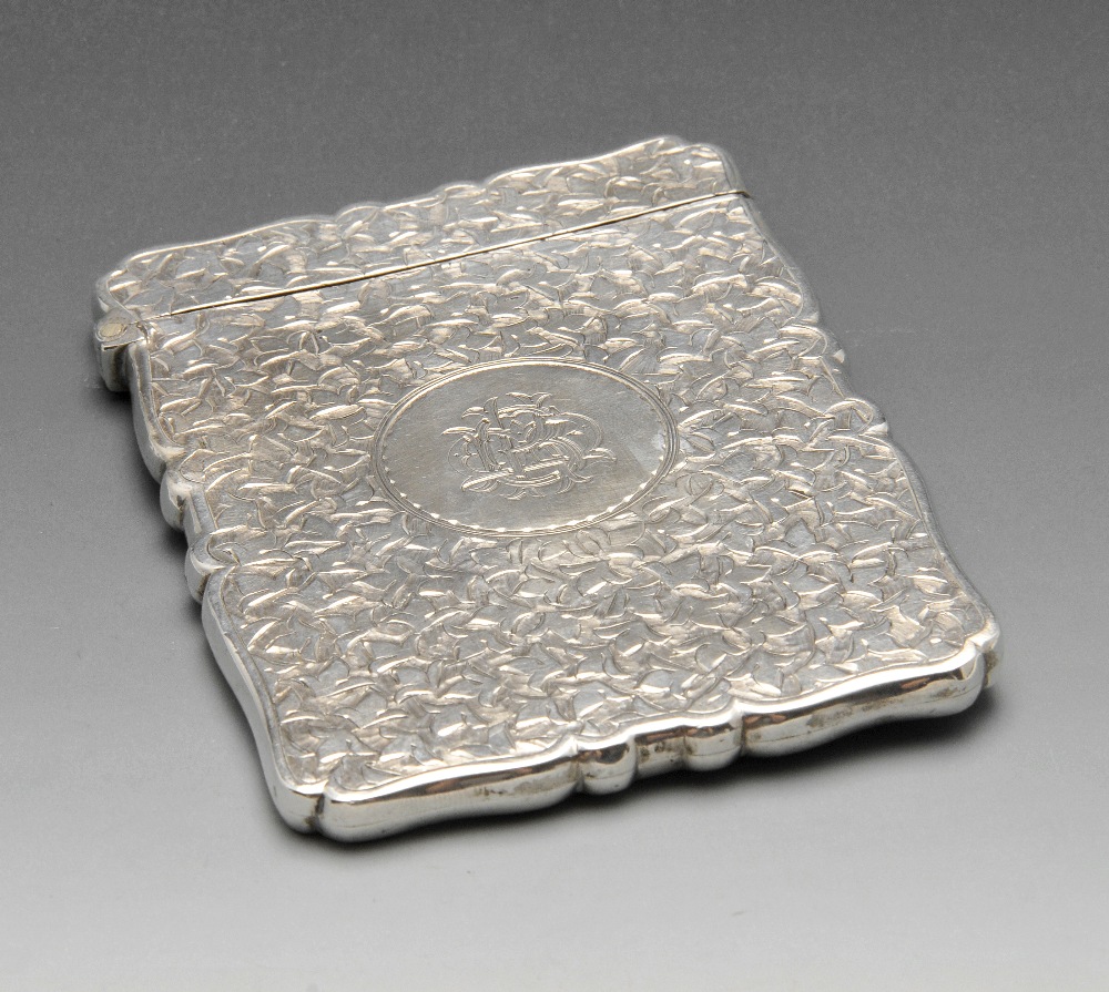 A late Victorian silver card case, the oblong form with scalloped edge entirely decorated with