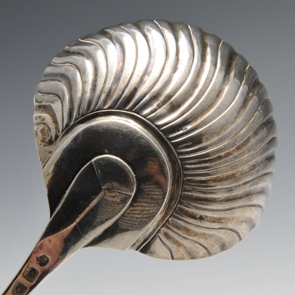 An early George III silver soup ladle with shell and scroll terminal and crest engraving to the - Image 3 of 6