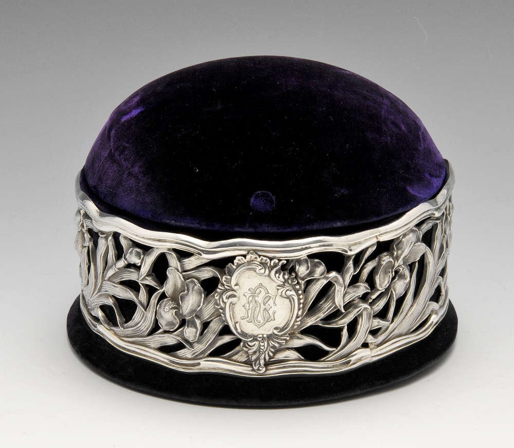 An Edwardian Art Nouveau silver mounted jewellery box, the circular velvet covered box with domed