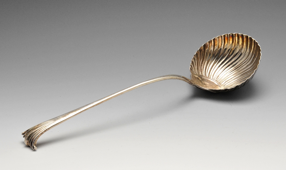 An early George III silver soup ladle with shell and scroll terminal and crest engraving to the