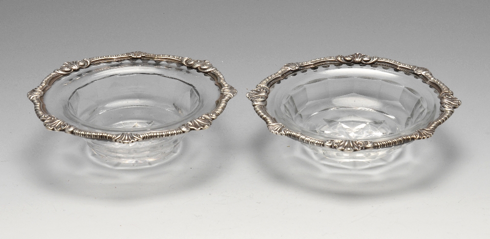 A pair of silver mounted cut glass dishes, the faceted bowl rising to the everted rim with shell and