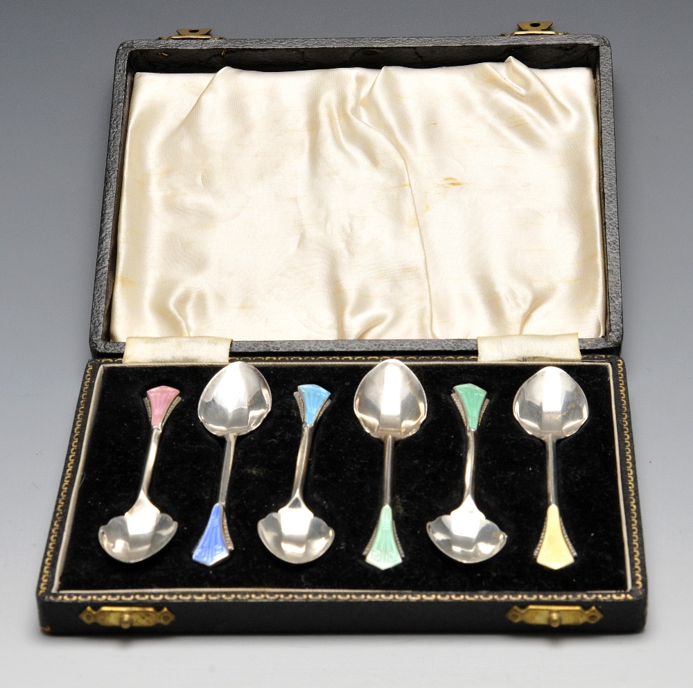 A cased set of Art Deco enamelled coffee spoons, the faceted bowls with shaped shoulders rising to