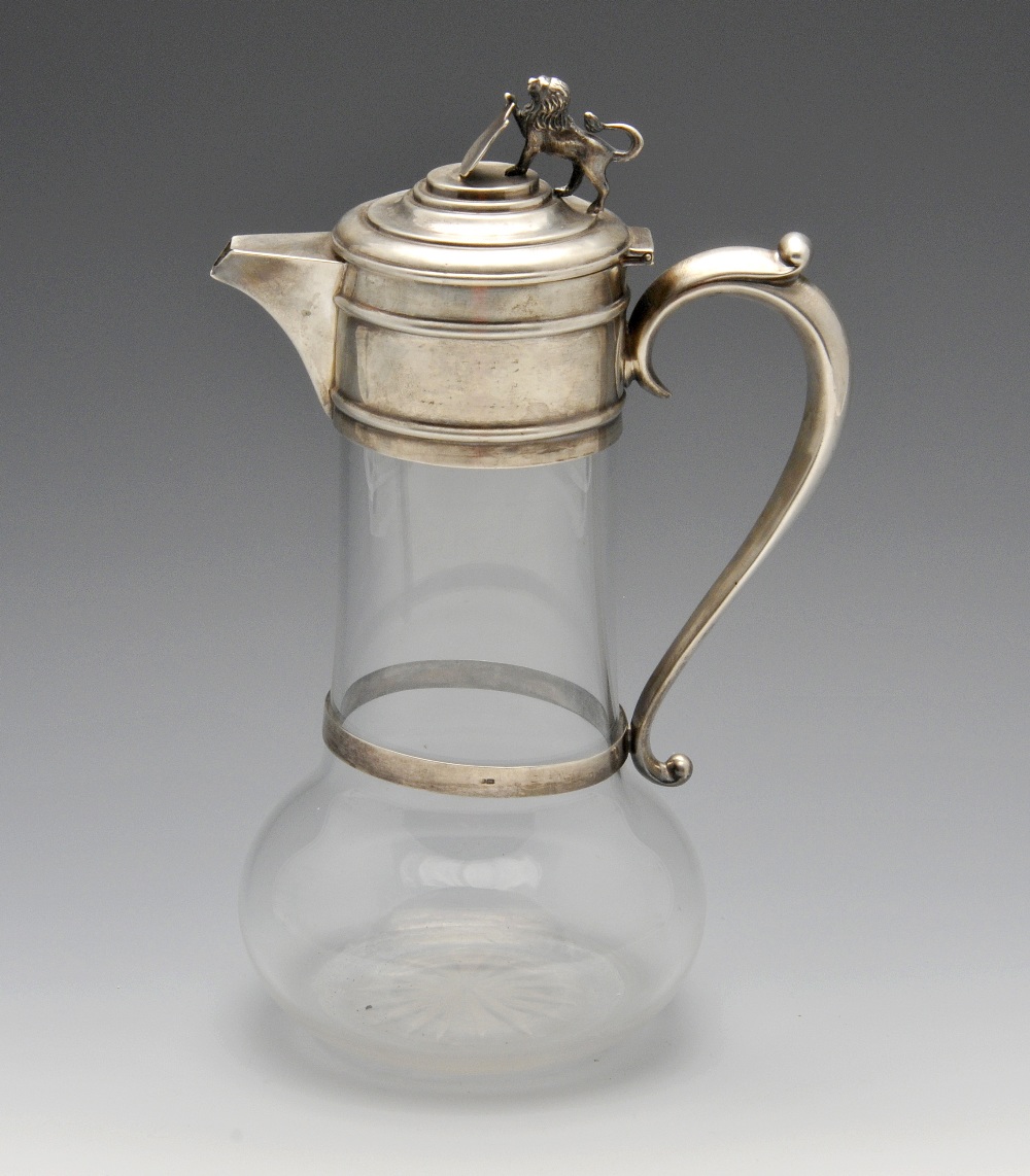 A late Victorian silver mounted claret jug, the clear glass body with bulbous base rising to a