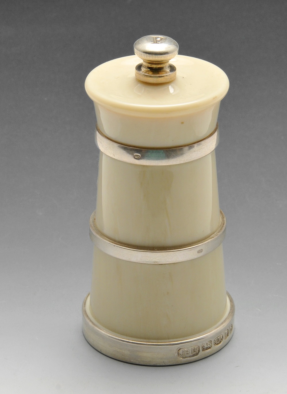 A modern silver mounted ivorine pepper grinder of tiered and banded form. Hallmarked London 2007.