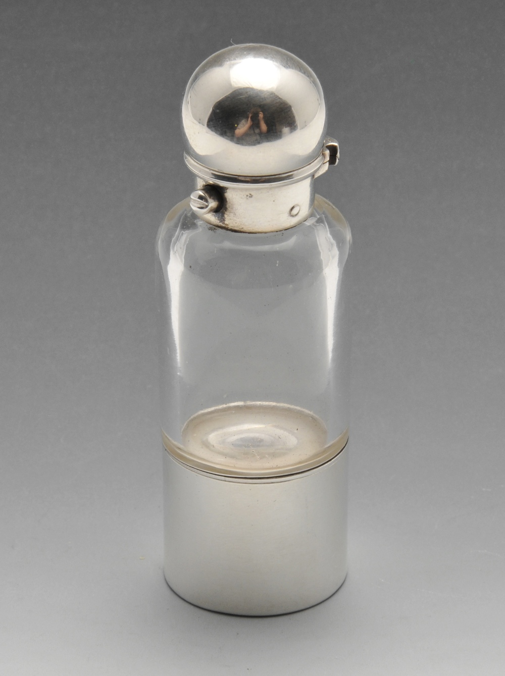 A Victorian combination scent bottle and sovereign holder, the clear glass cylindrical body with