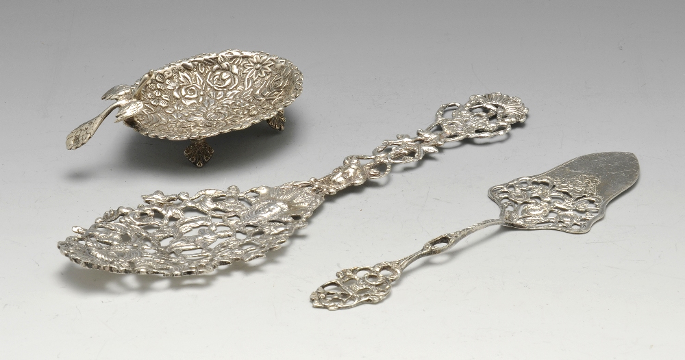 An Egyptian silver trinket dish, florally decorated and with peacock handle, maximum length