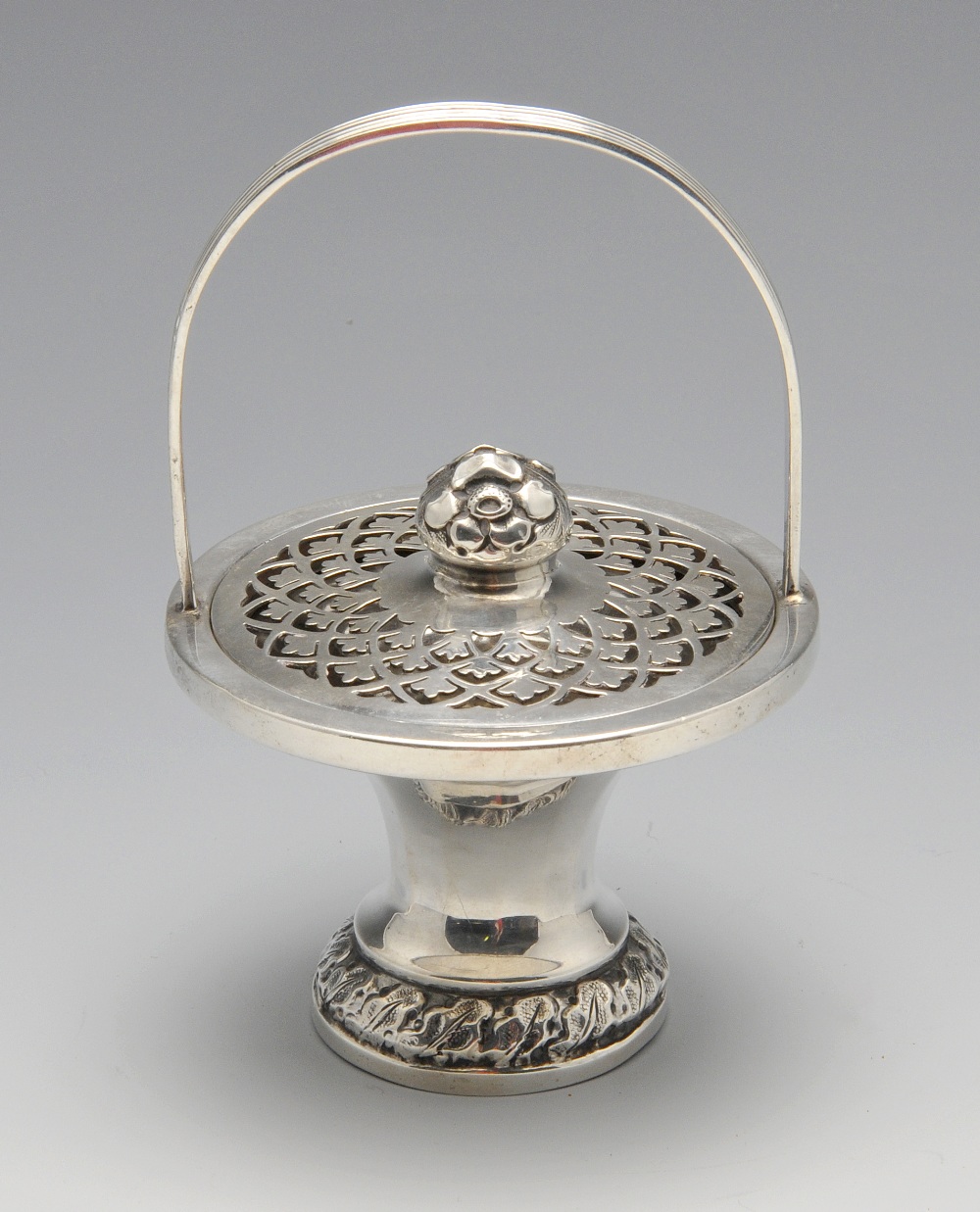 An early twentieth century silver pot pourri basket, the faceted, spreading form with a formalised