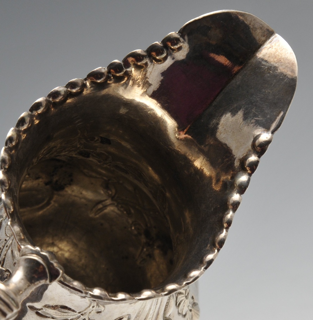 A George III silver cream jug, the bellied form with oblique fluting and beading amidst floral - Image 4 of 5