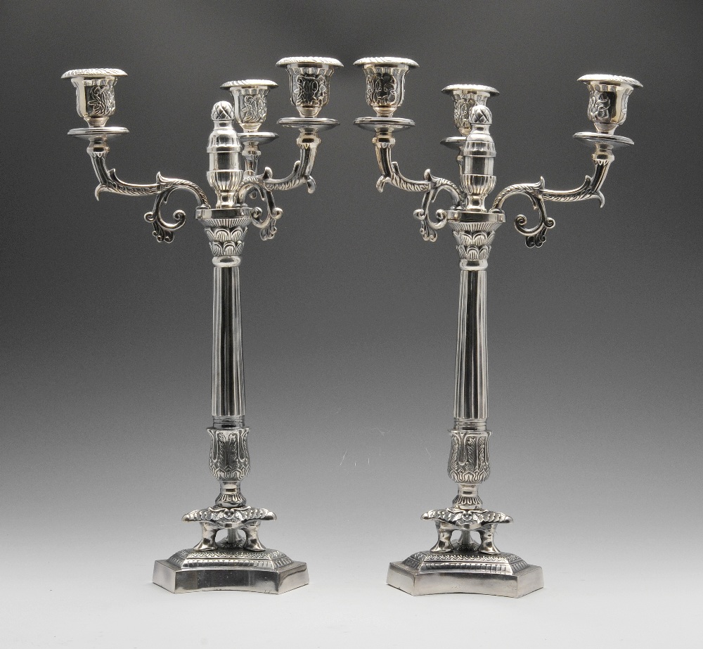 A pair of modern silver plated candelabra of Empire style, the tri-form base rising to the foliate