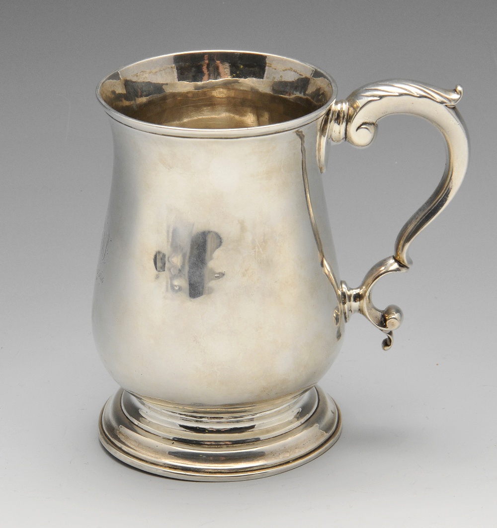 A George III silver mug, the classic baluster form with later personal inscription, standing on a