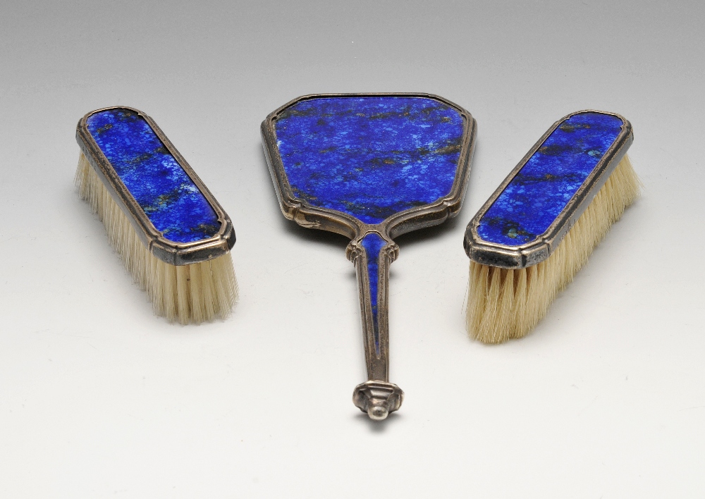 A 1930's silver and enamel part dressing table set, comprising a hand mirror and a pair of clothes