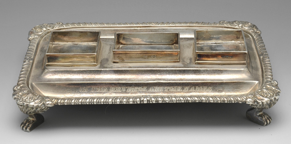 A George III silver desk stand of oblong form, having a gadroon rim with foliate shell borders and