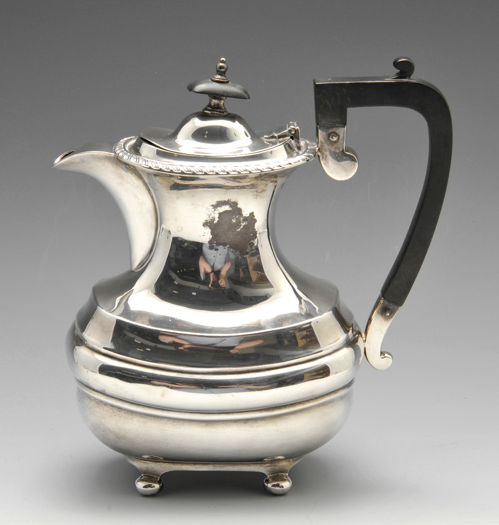 A 1920's silver hot water pot, of bulbous oblong form below a waisted neck and gadrooned rim, having