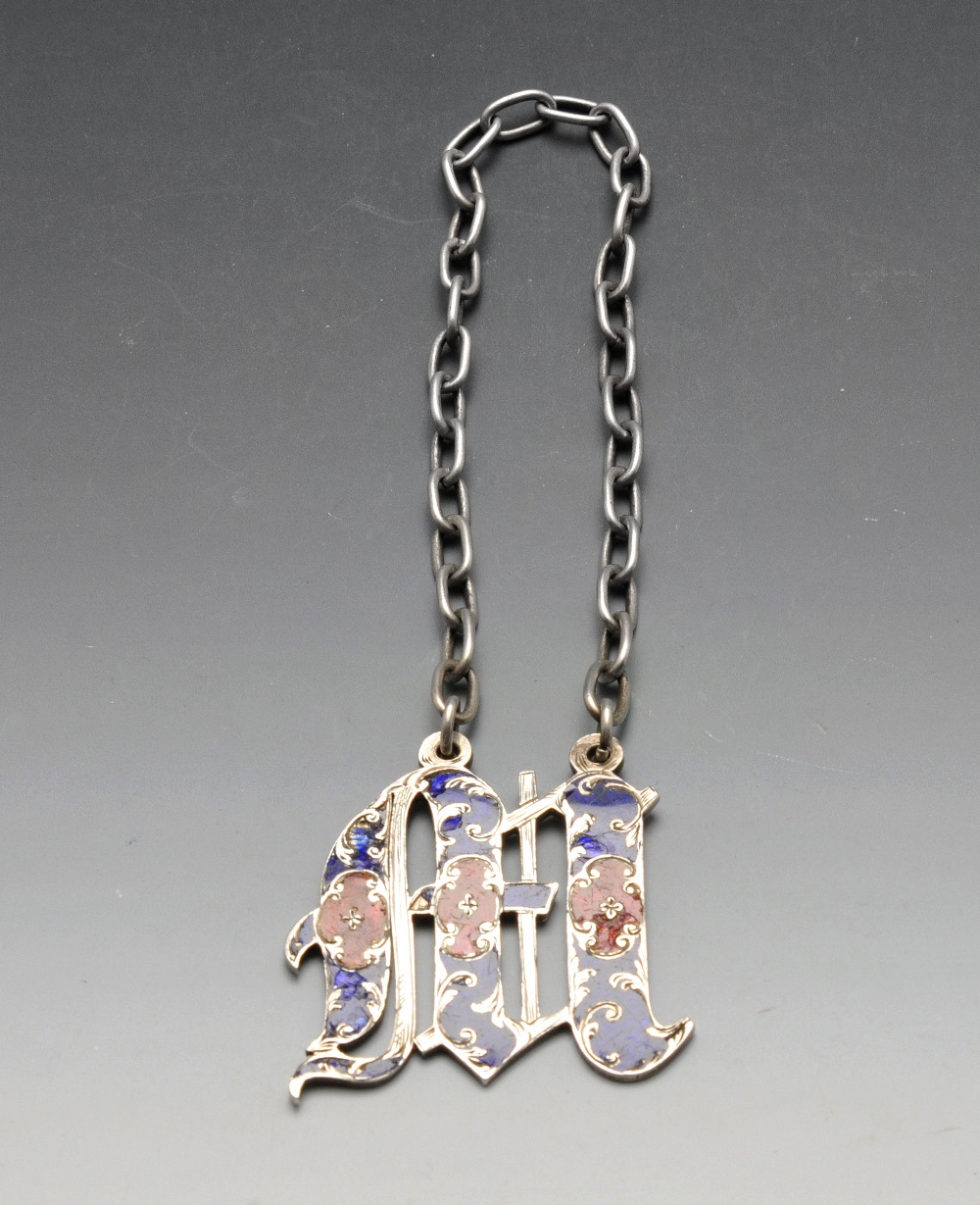 An early Victorian silver wine label, the letter 'M' enamelled in red and blue on wide suspension