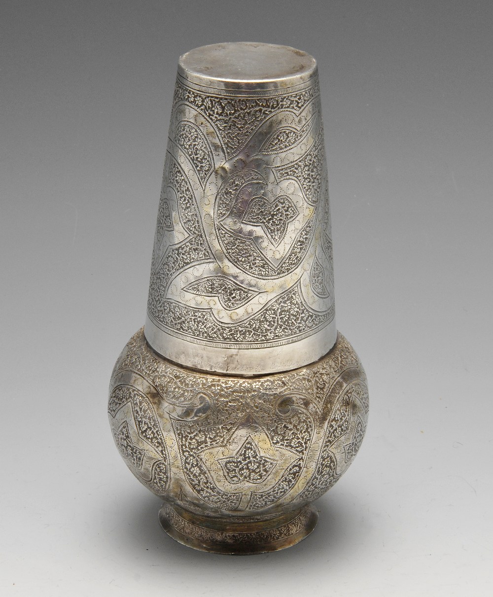 A Persian jug of vase form and ornately close chased with foliate decoration and matching tapered