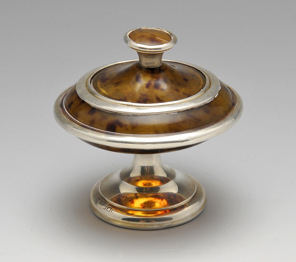 A 1920's silver mounted tortoiseshell box, the elliptical form standing on a pedestal foot.