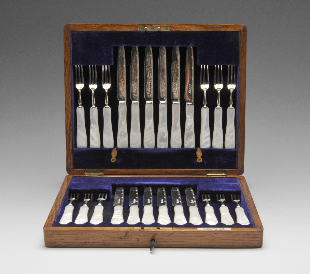 An Edwardian cased set of silver mounted fruit knives and forks for twelve place settings with