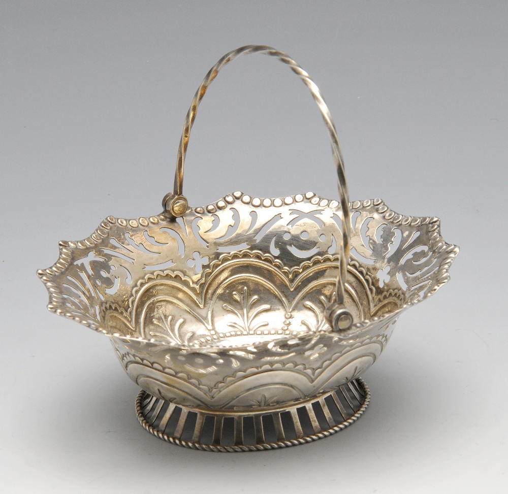 An early George III sweet-meat basket, the oval body rising to the scroll pierced border and twist