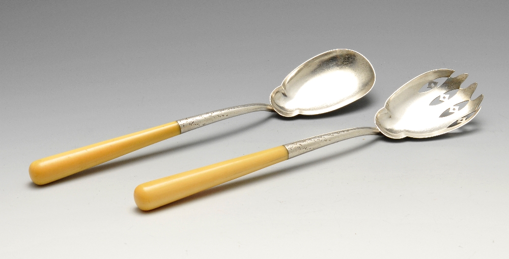 A pair of late Victorian silver mounted salad servers, the shaped pierced and florally engraved