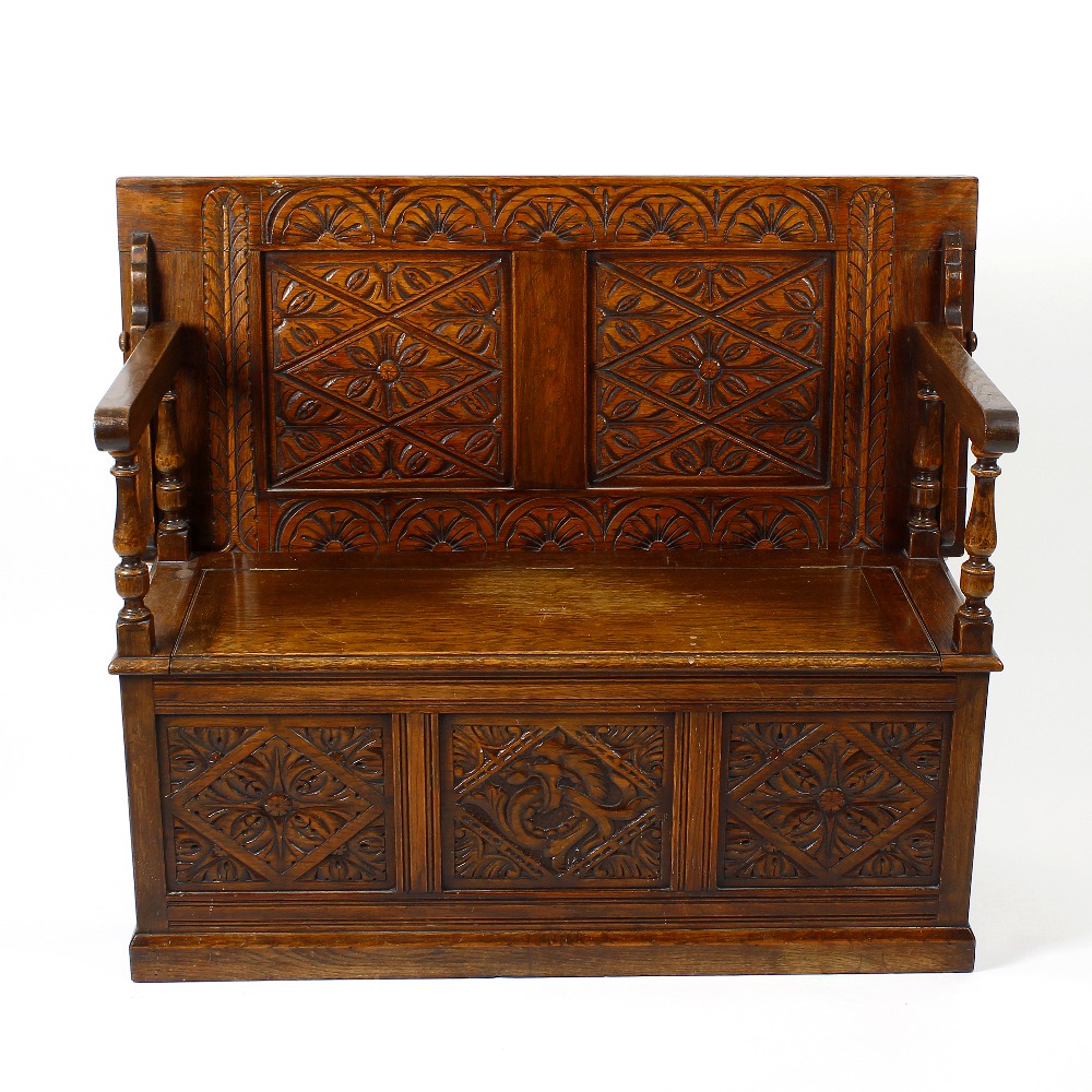 An early 20th century oak 'monk's bench'. Of typical form, the rectangular turn-over top with