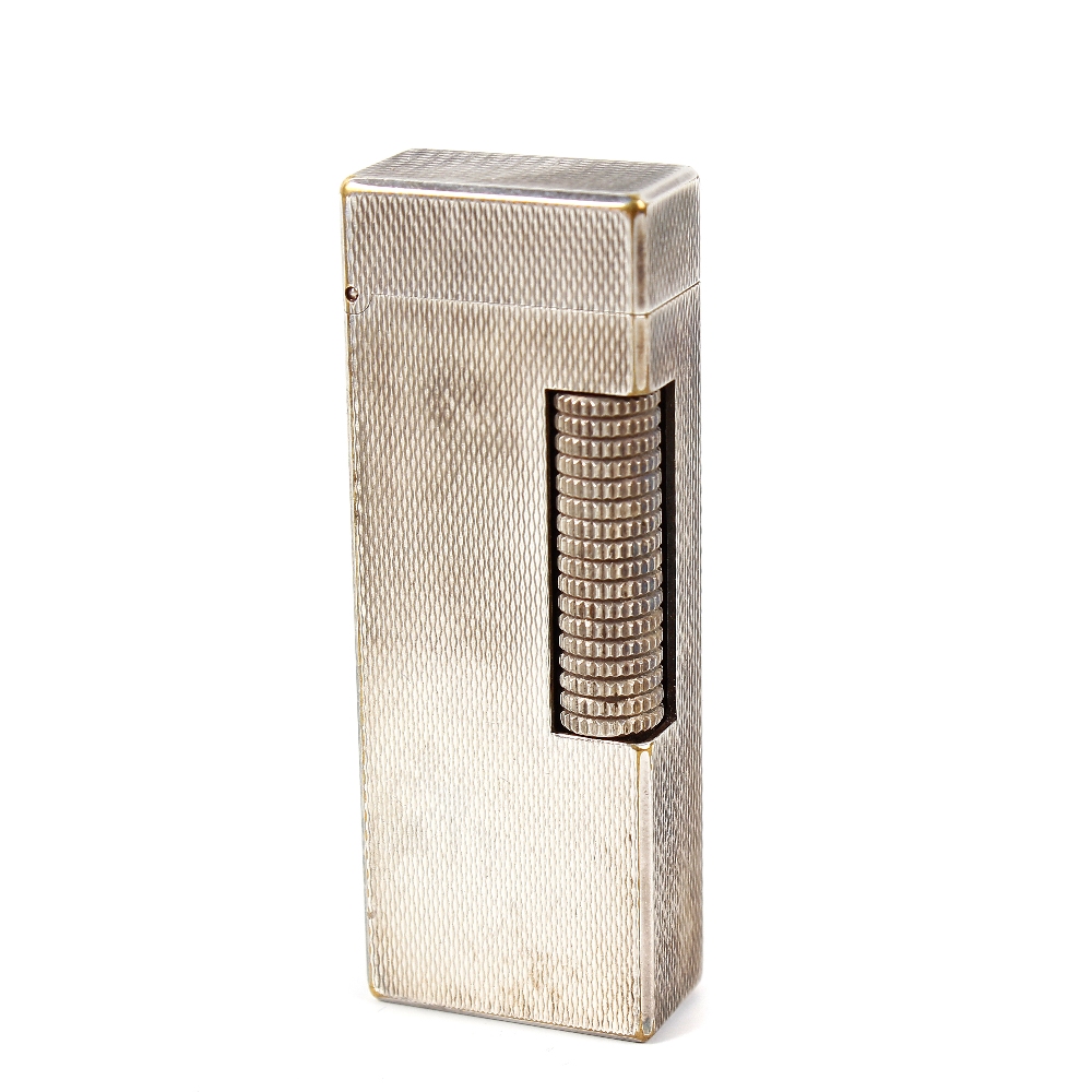 A Dunhill rollagas lighter, the rectangular shaped body with engine turned decoration, impressed